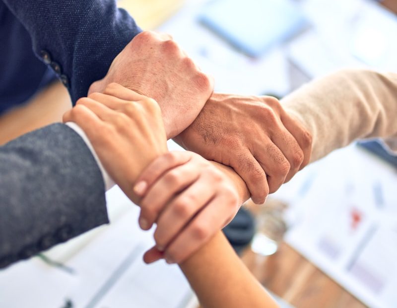 person in black long sleeve shirt holding persons hand